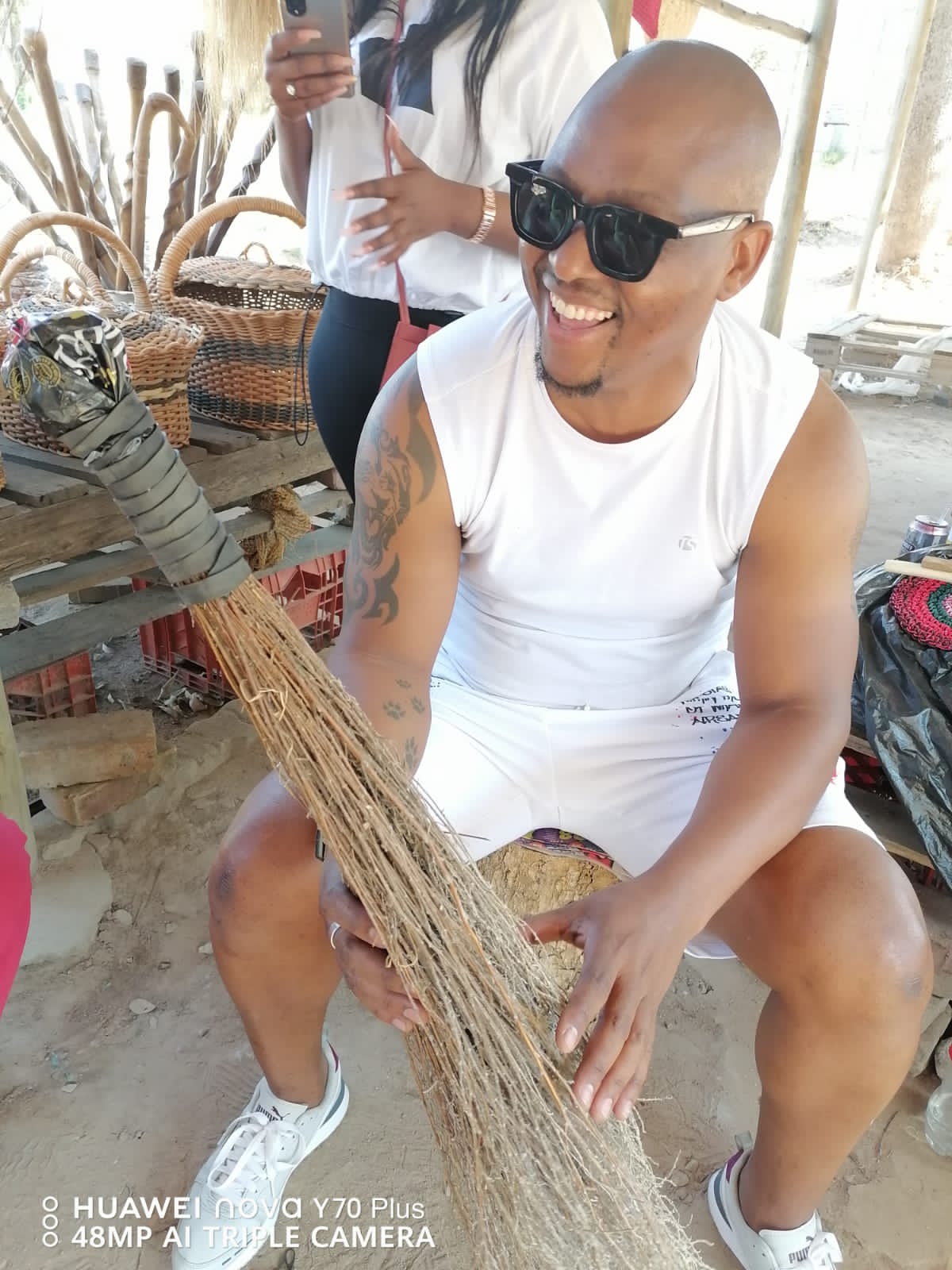 A participant laughing while making a grass broom