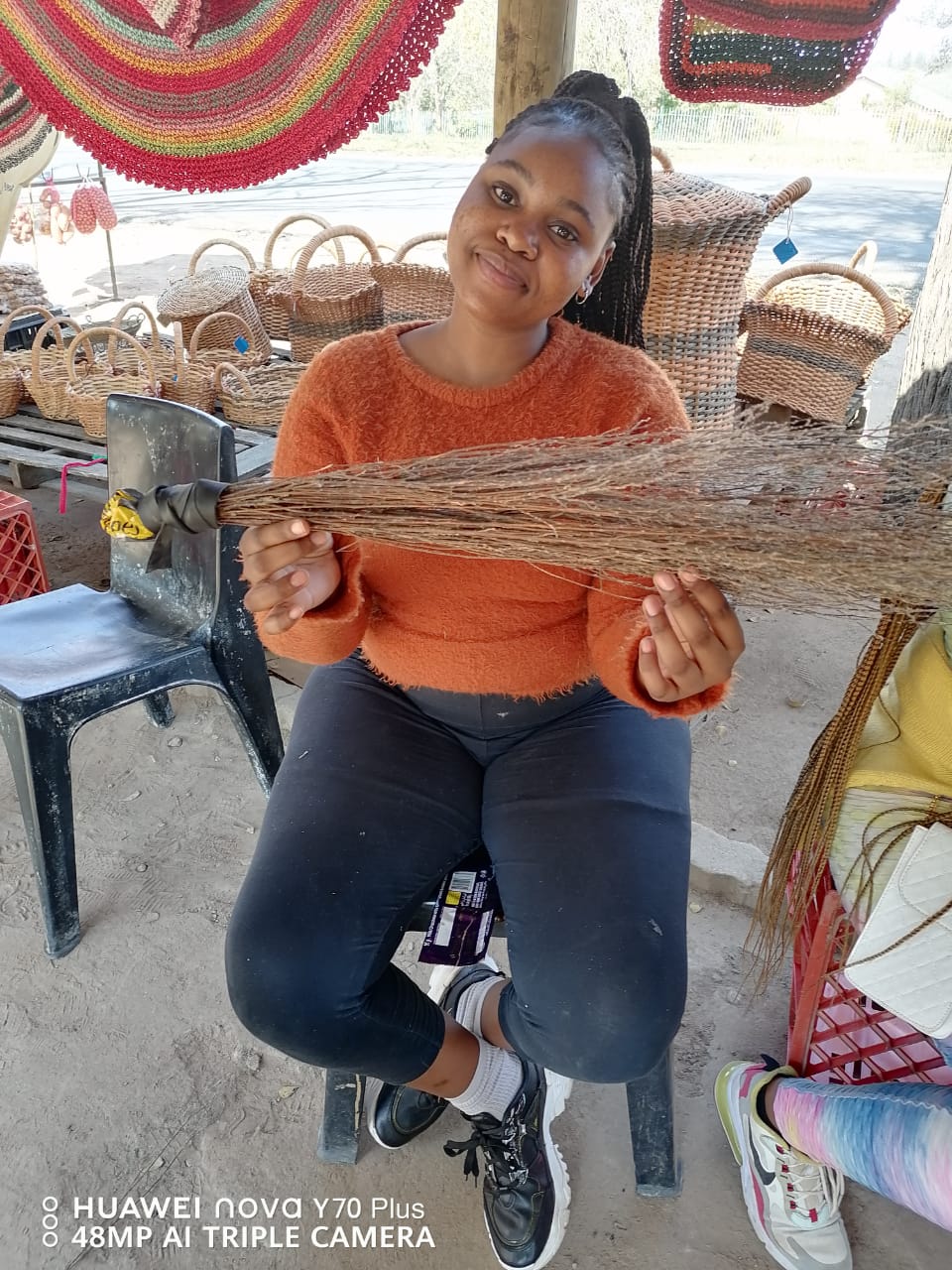 A participant holding a hand-made grass broom